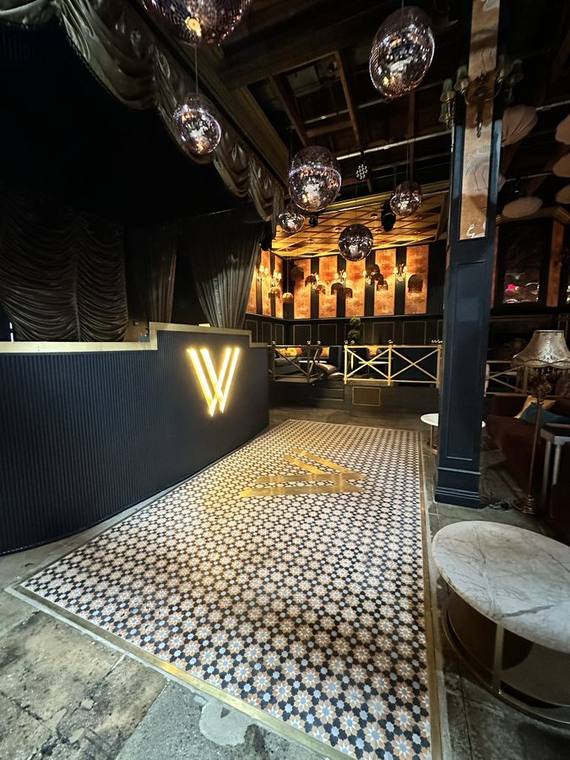 Mosaic floor with inlaid house logo, laid by hand