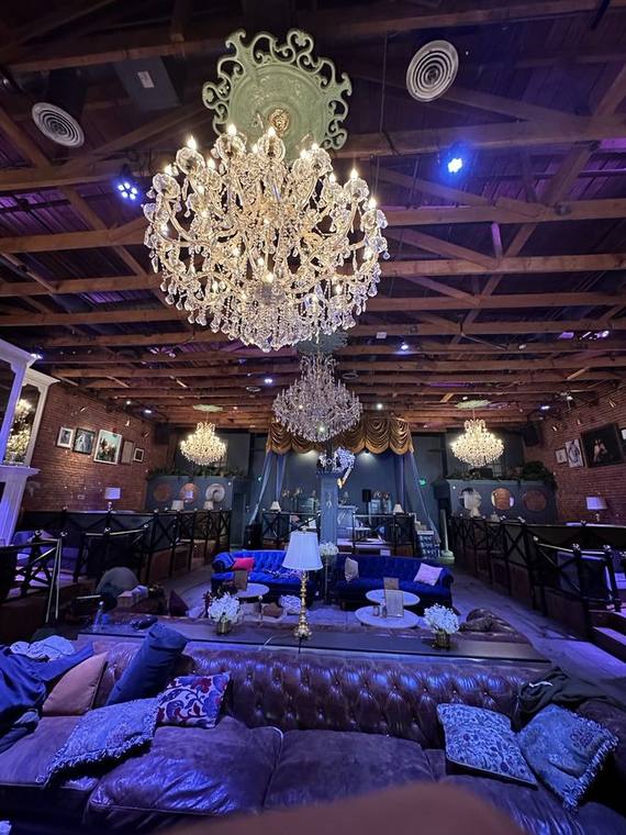 Lounge with chandeliers hung under open timber trusses